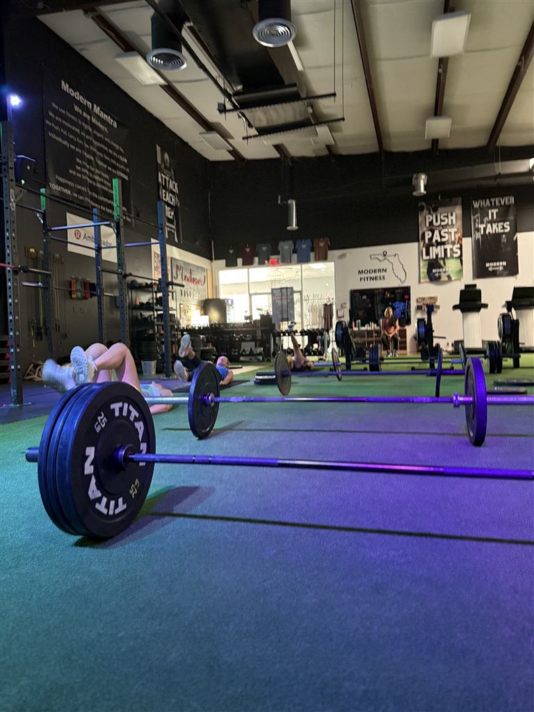 Modern Fitness gym floor with barbells and members training